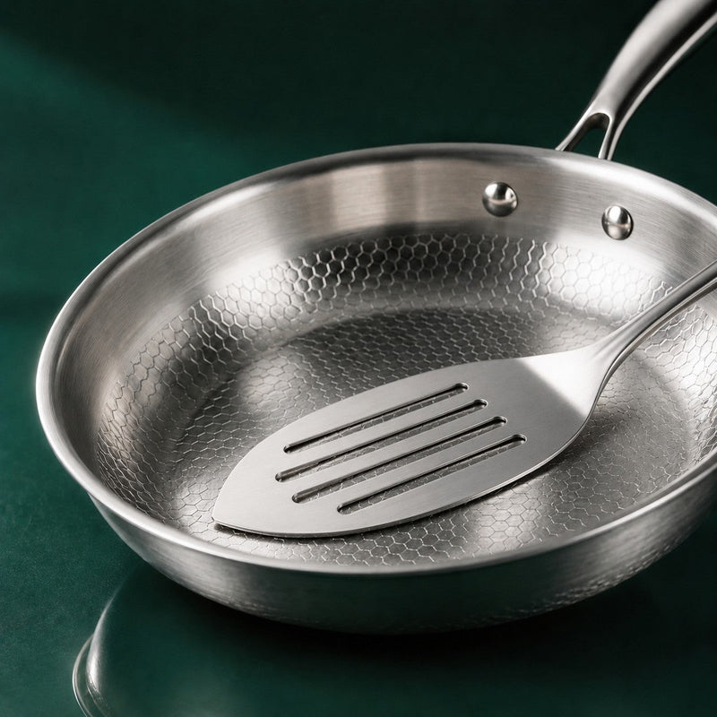 A stainless steel fish slice resting on the uncoated surface of The Sunday Pan