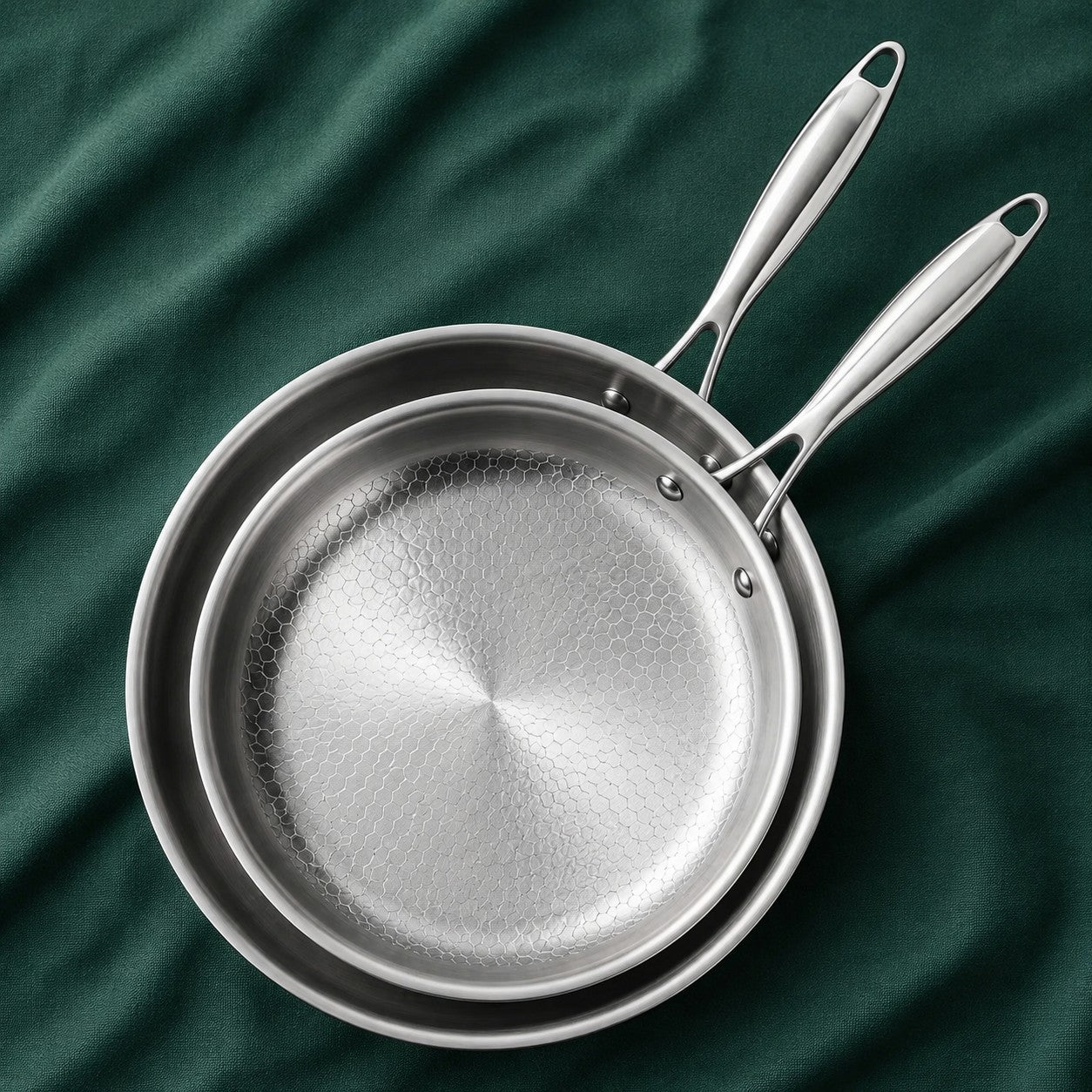 The Chef's Pair, 28cm and 24cm titanium pans nested on dark green cloth